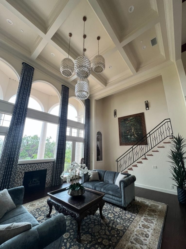 Finished painted living room with high ceilings and a staircase