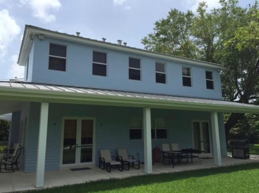 Finished painted home exterior with a covered patio