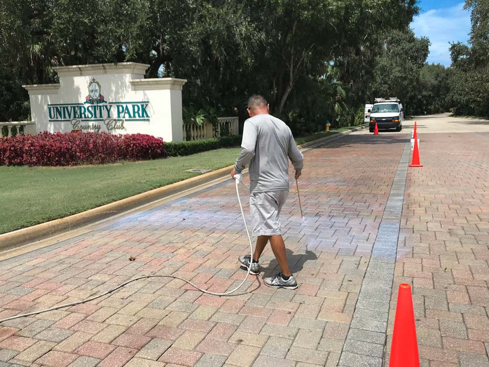 Cleaning a paver driveway at a community entrance